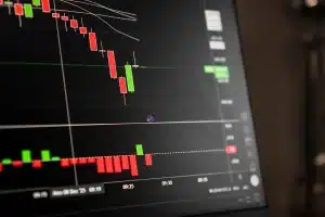 Operatori di borsa osservano grafici di mercato su schermi mentre seguono l'andamento dei titoli