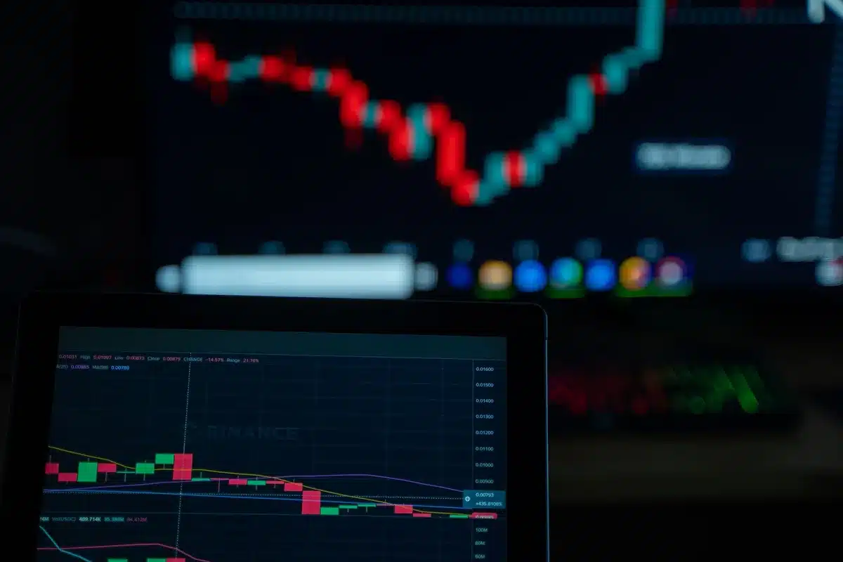Analista finanziario al lavoro con grafici di mercato e linee di tendenza al ribasso