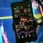 Grafico di calo azionario con schermi finanziari su una sala di trading