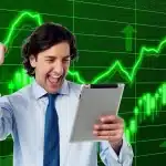 Scrivania di trading con report e schermo che mostra grafico azionario in calo