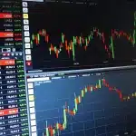Sala di contrattazione vuota con monitor e silhouette di operatori finanziari