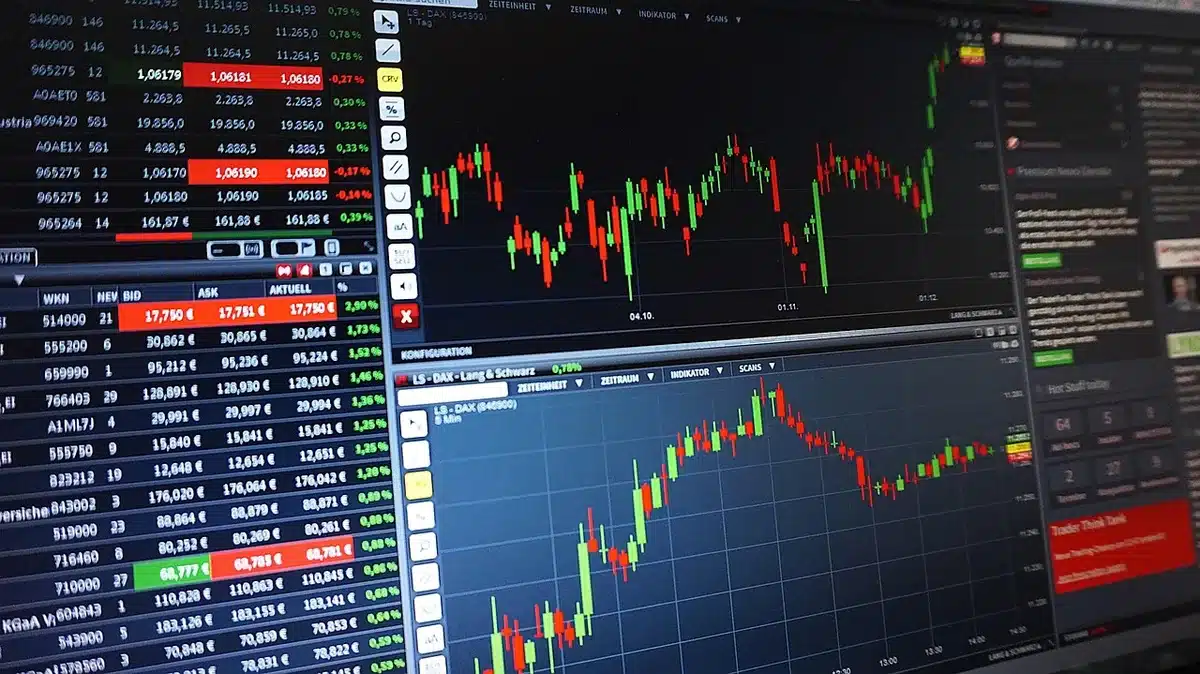 Sala di contrattazione vuota con monitor e silhouette di operatori finanziari