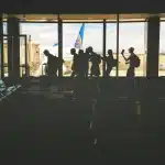 Terminal aeroportuale con silhouette di passeggeri e un aereo in lontananza