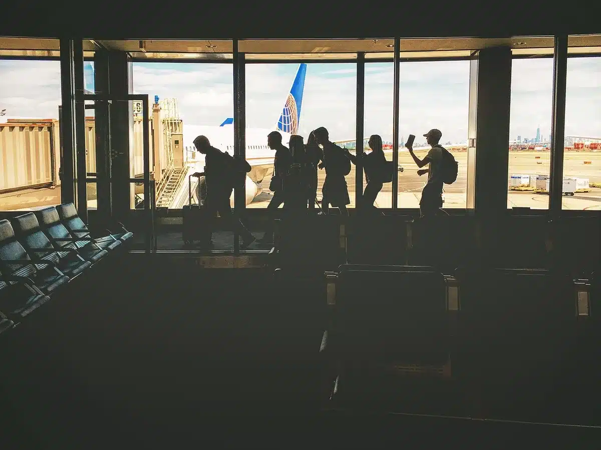 Terminal aeroportuale con silhouette di passeggeri e un aereo in lontananza