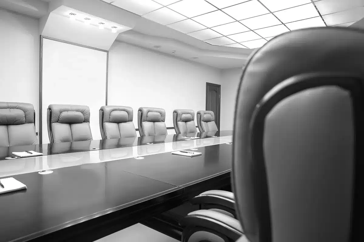 Membri anonimi di un team in riunione discutono documenti sul tavolo
