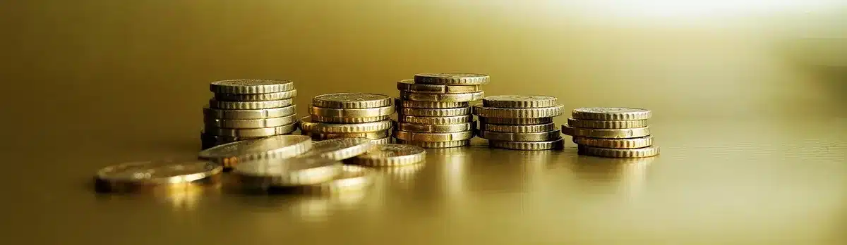 Mano su pila di monete vicino a documenti finanziari