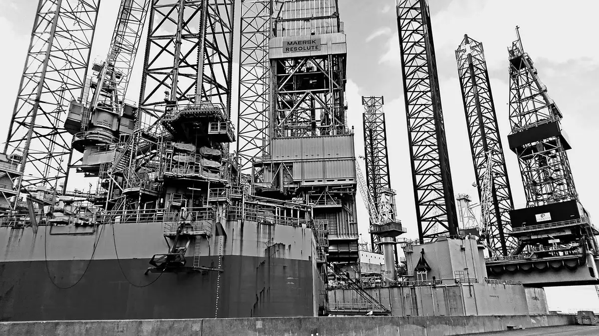 Piattaforma petrolifera all'orizzonte con cielo limpido che evoca il mercato energetico